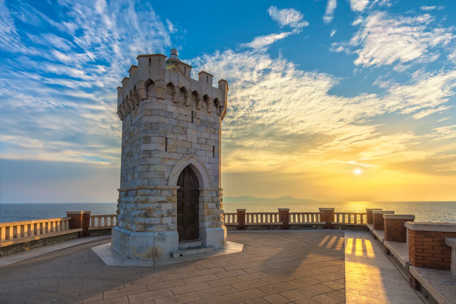 Vista del atardecer del faro de Piombino Piazza Bovio y la isla de Elba al fondo