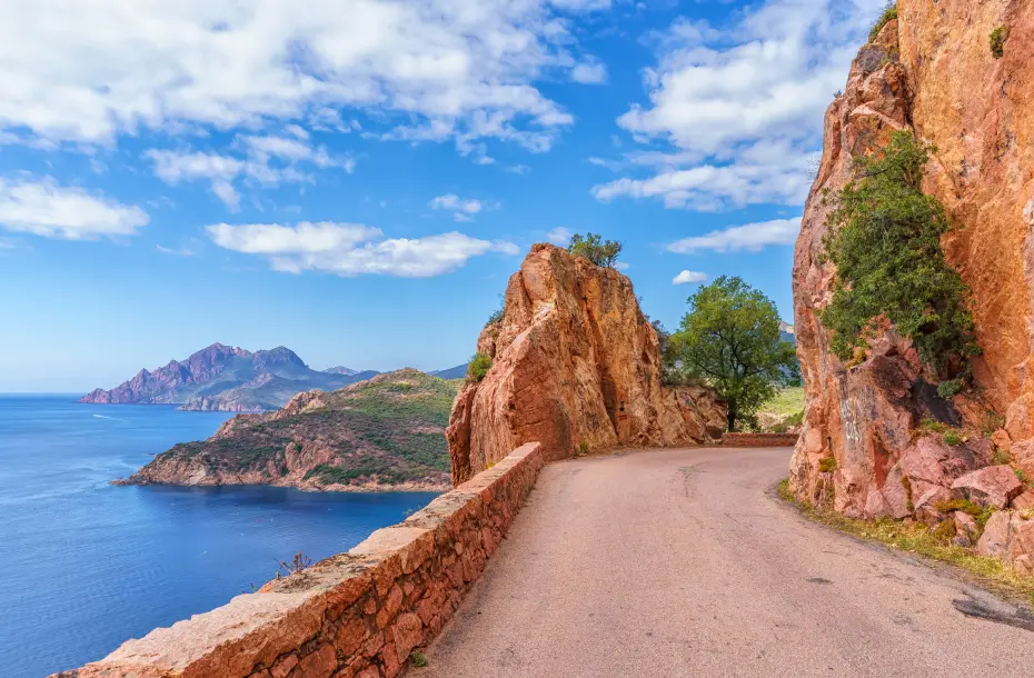 Carretera de montaña colorida con vista al mar a un lado, en Calanques De Piana en Córcega, Francia